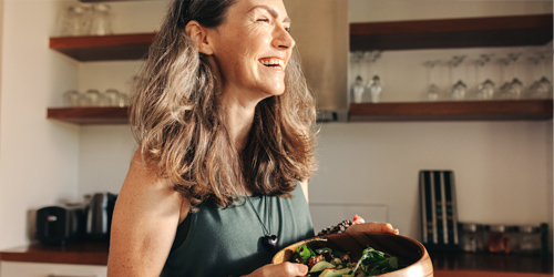 Mujer cocinando, sonriendo a la cámara. Mujer cocinando, sonriendo a la cámara.